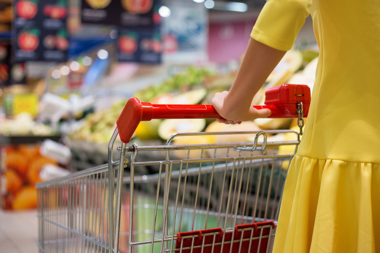 woman in yellow dress pushing grocery shopping cart