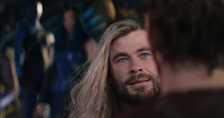 Thor (Chris Hemsworth) looking into Peter Quill's (Chris Pratt) eyes, with the Guardians in the background