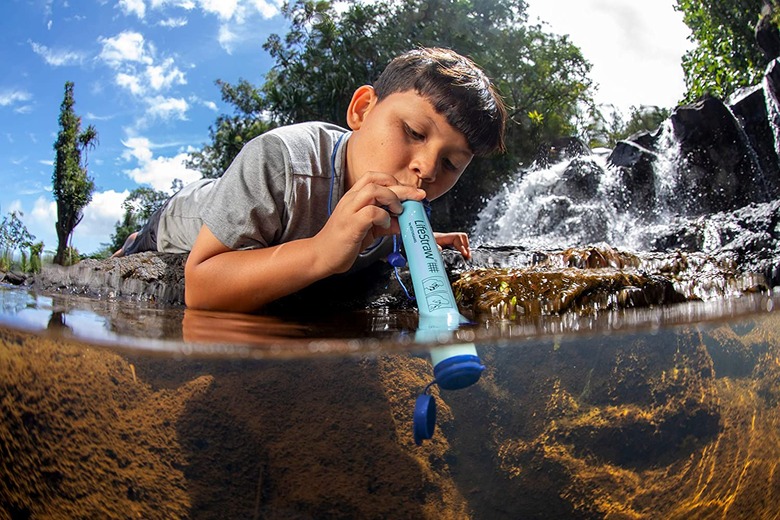 A child using the LifeStraw in a stream
