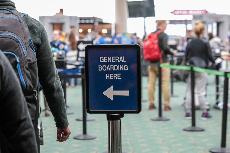 Line of people at airport sign