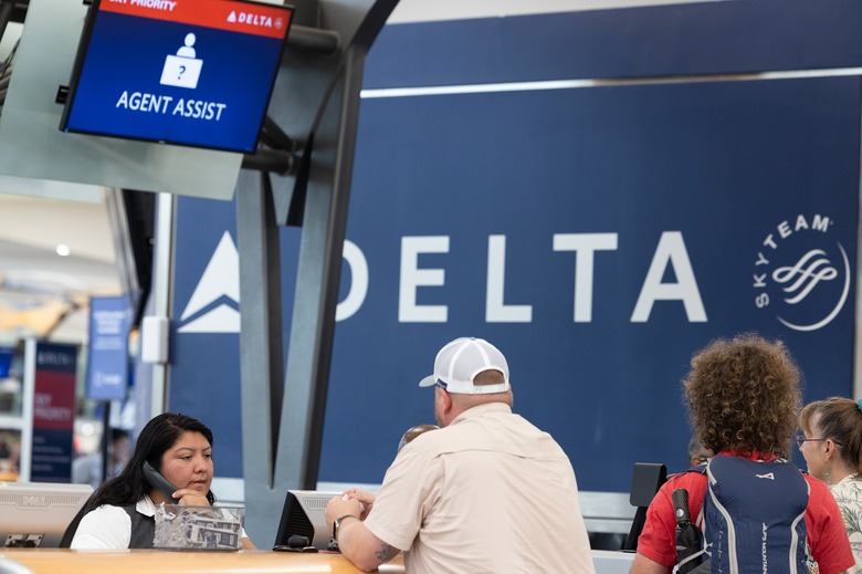 A Delta agent helps passengers after cancelled and delayed flights at Hartsfield-Jackson Atlanta International Airport on July 22, 2024 in Atlanta, Georgia.