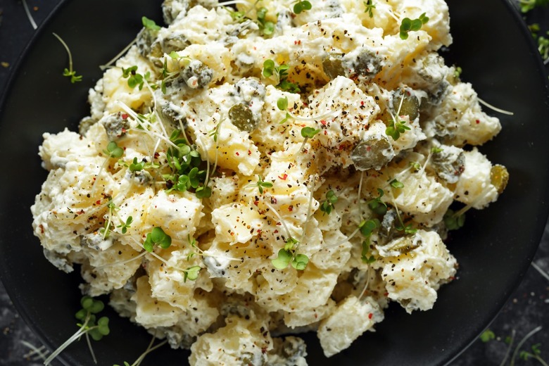 Potato salad on a black plate.
