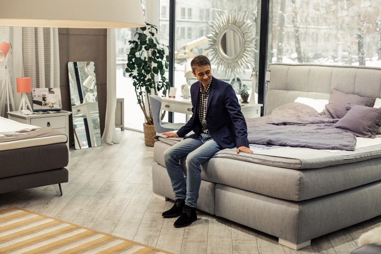 A man testing a bed in a furniture store