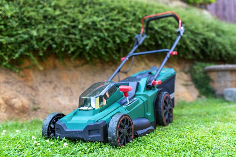 Modern cordless battery electric lawn mower in the garden.