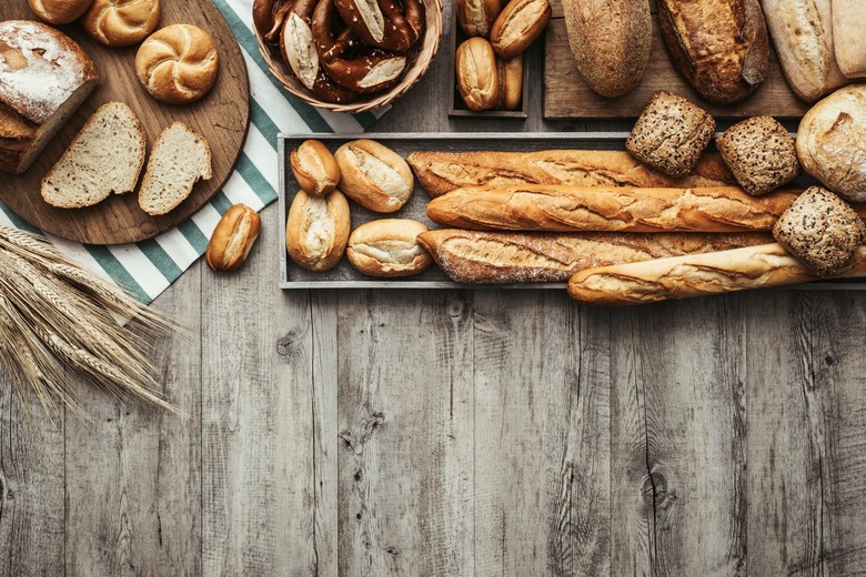 Freshly baked delicious bread on a rustic wooden worktop.