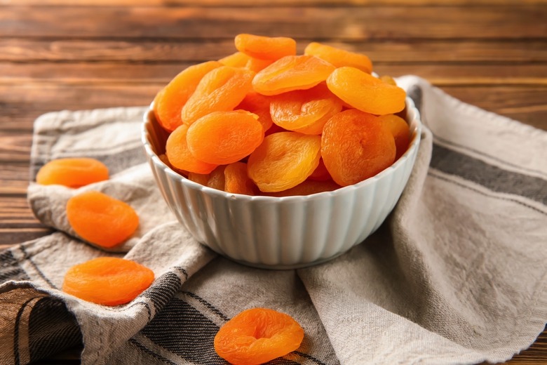 A bowl with dried apricots on a table