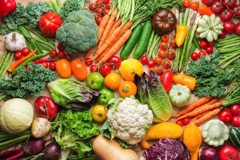 Assortment of fresh colorful organic vegetables on wooden pine table.