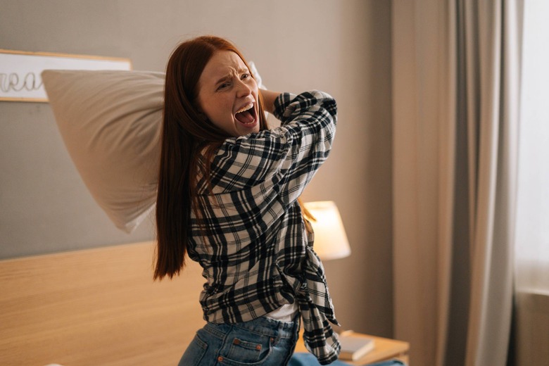 venting, angry woman swinging a pillow