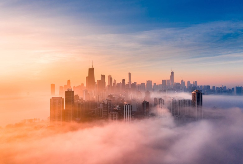 Chicago cityscape with fog covering it, sun rising in distance