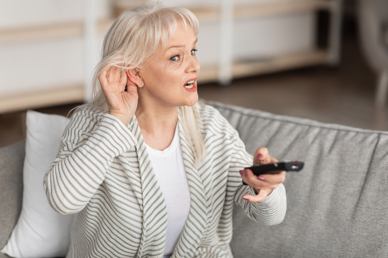 An older woman experiencing hearing loss.