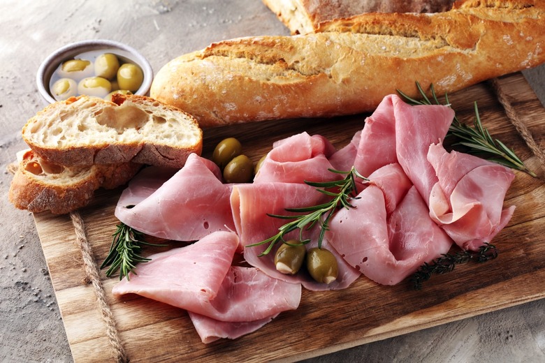 Sliced ham on wooden cutting board.