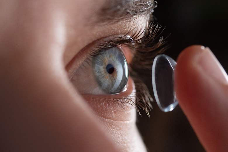 Close-up of a person putting contact lenses on someone else.