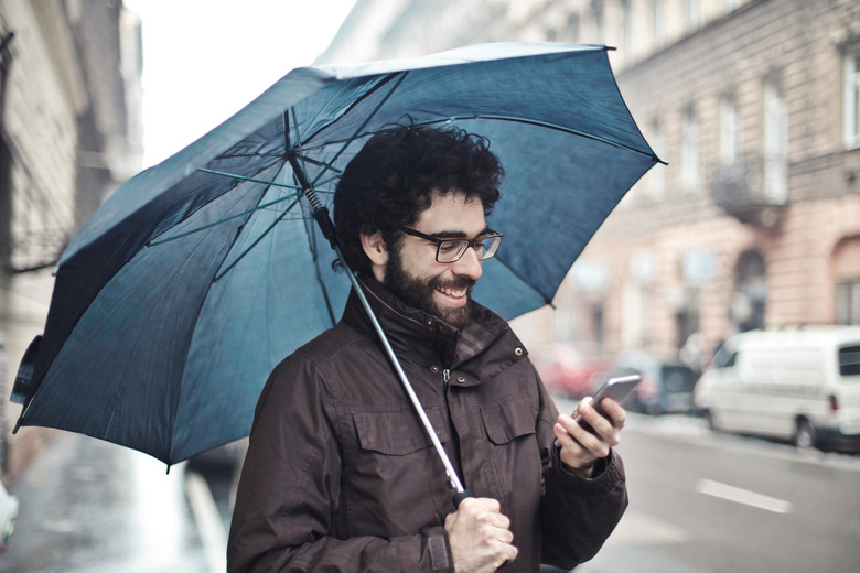 man with umbrella holding phone