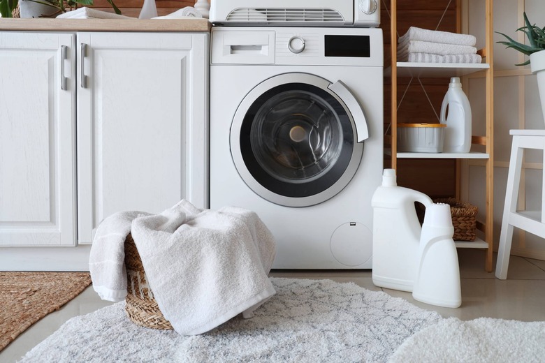 washing machine with clothes in front of it