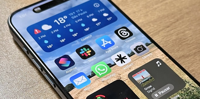 iPhone 15 Pro showing various apps, including the App Store and WhatsApp.