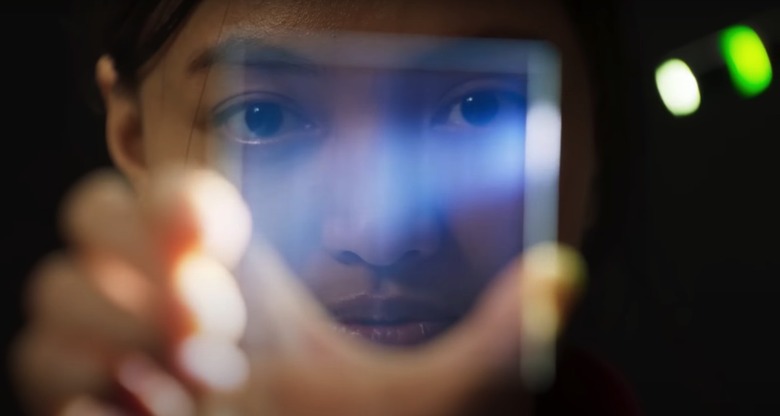 A person looking through a sheet of Project Silica glass.