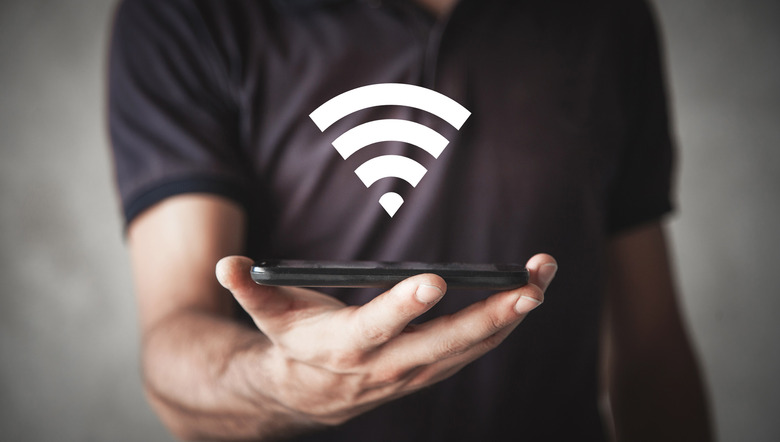 man holding phone, wi-fi symbol