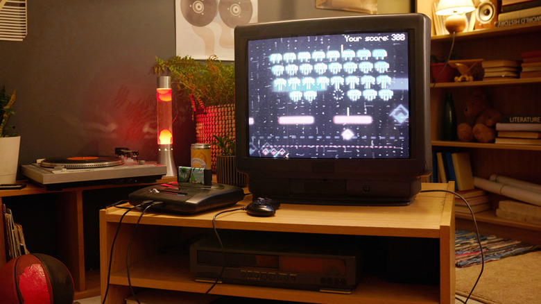 A 1980s style room with retro gadgets, such as a CRT TV, gaming console, and VCR.