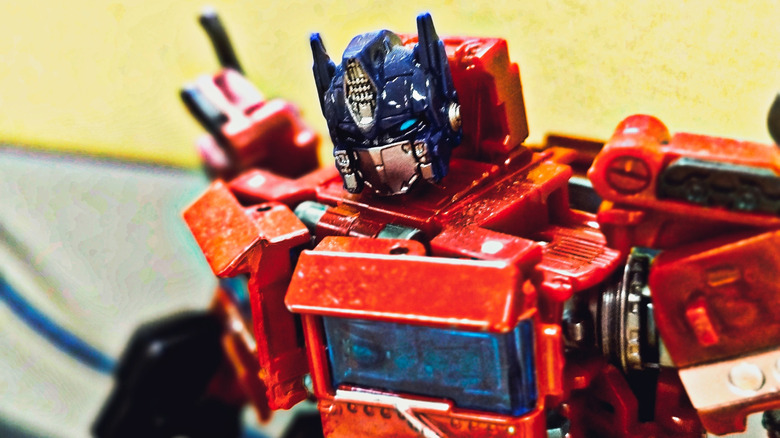 Close-up photo of a red and blue Optimus Prime action figure with detailed mechanical features and weathered paint effects.