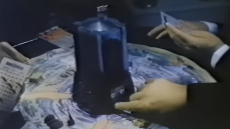 Vintage electronic tabletop game setup featuring the Milton Bradley Dark Tower device surrounded by players' hands, cards, and game pieces.