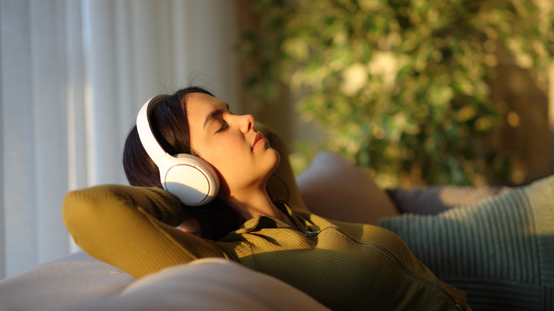 A woman wearing headphones and listening to soothing music.