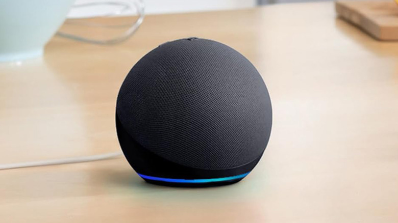 An Amazon Echo Dot on a light wood table.
