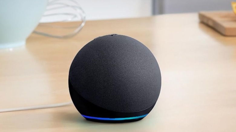The Amazon Echo Dot (5th Gen) smart speaker on a wooden surface.