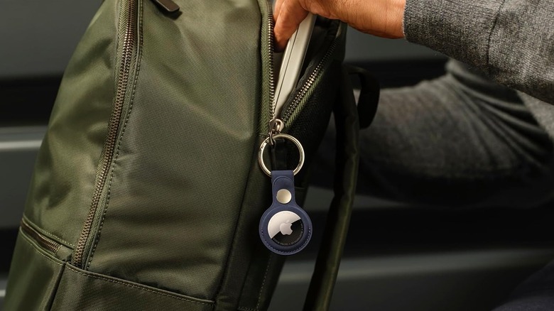 The Apple AirTag (2nd Gen) tracking device attached to a backpack's zipper.
