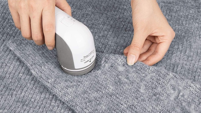 Fabric Shaver going over a small pile of lint on a sweater