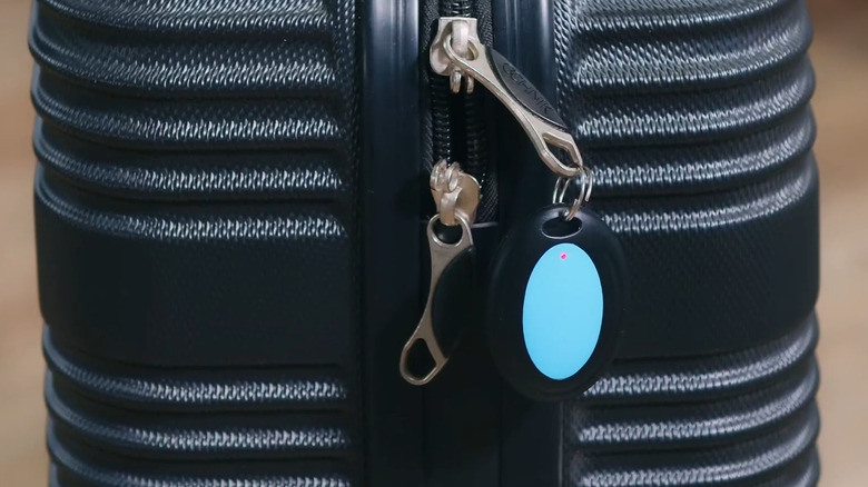 Reyke Button attached to the side of a suitcase zipper