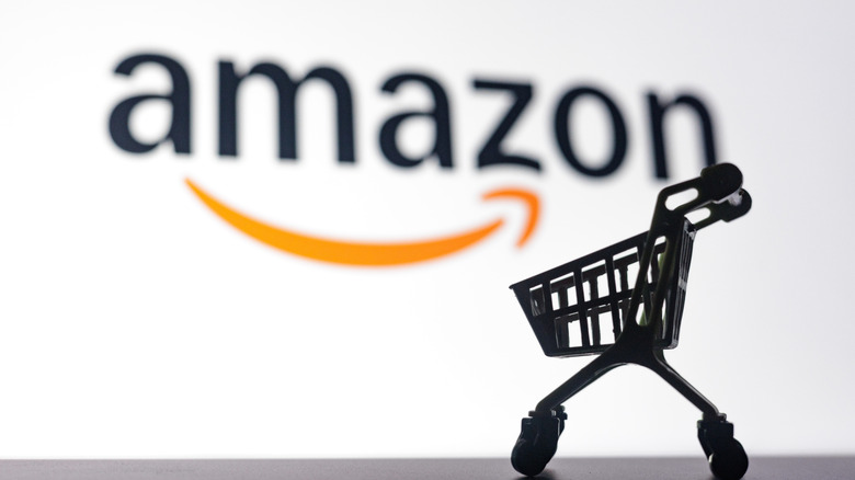 A mini shopping cart in front of the Amazon logo.
