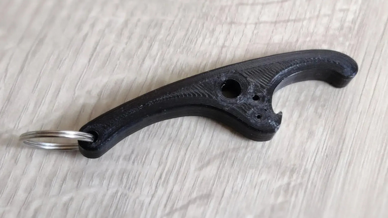 Bottle opener with a keychain loop on the back on a white table