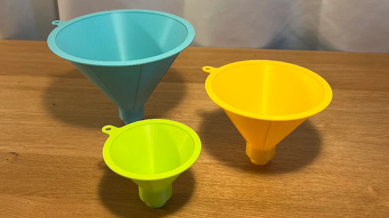 A trio of screw on funnels on a wooden kitchen table