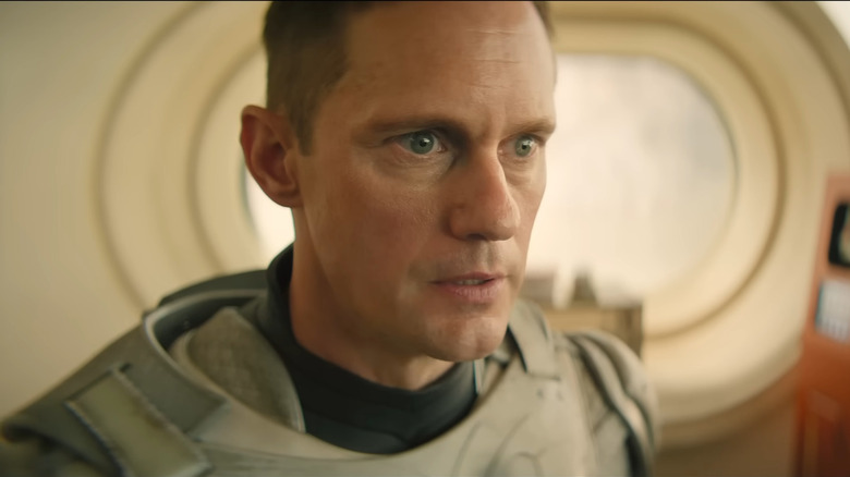 Alexander Skarsg﻿ård as Murderbot, standing in the research center