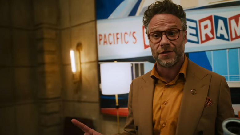 Seth Rogen as Matt Remick speaking at the front of an office during a meeting