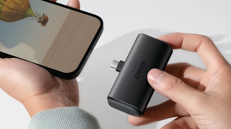 A person about to insert the Anker Nano power bank into the USB-C port of a phone.