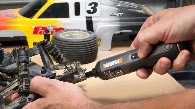 A person working on an remote control car using the Worx WX240L electric screwdriver.