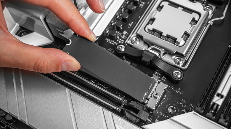 Person installing an SSD into a motherboard