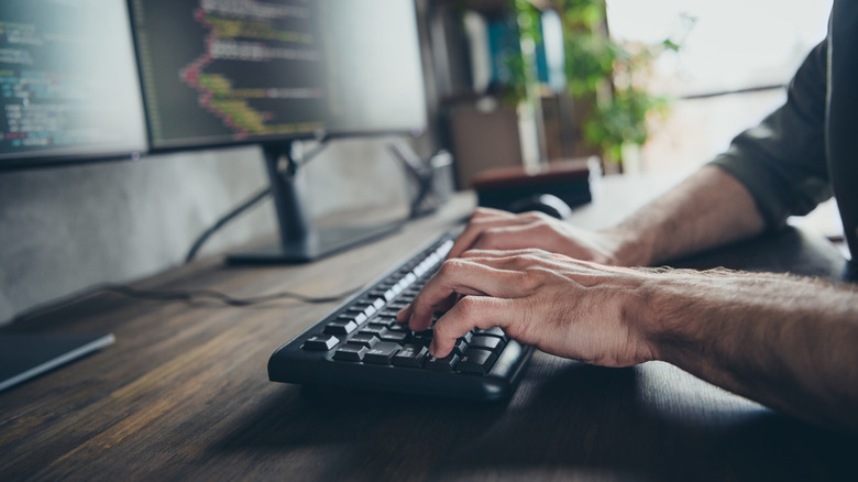 A man typing at a workstation