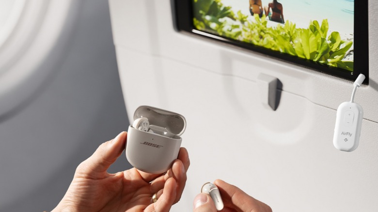 Person connecting airpods to AirFly Pro 2 on airplane