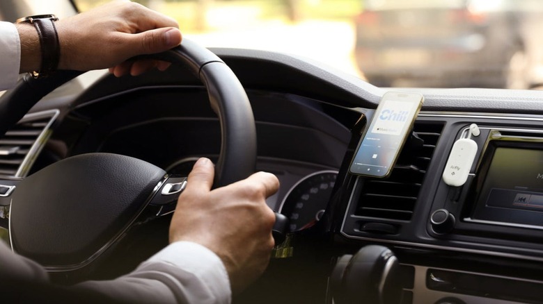Person connecting a phone to an Airfly Pro 2 in a car