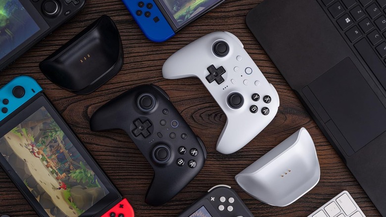 8BitDo controllers on table with Nintendo Switch consoles and laptop