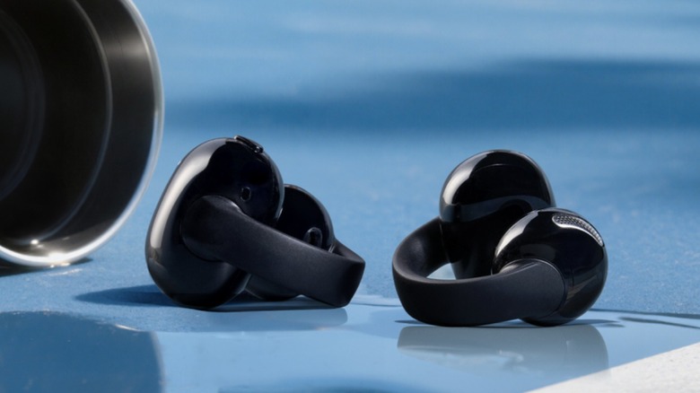 The Anker Soundcore C50i clip-on earbuds on a wet floor.