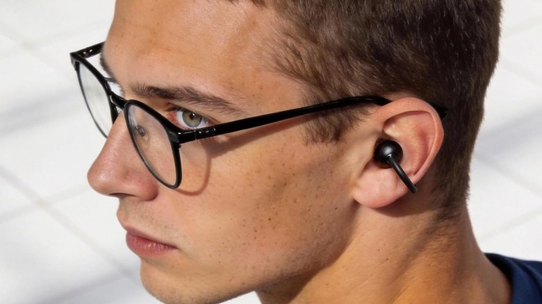 A person wearing the Tozo Open EarRing open-ear earbuds.