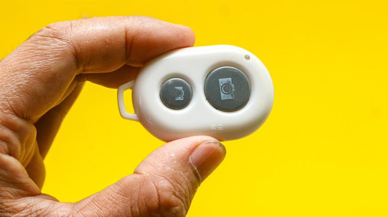 A man holding a bluetooth camera remote shutter