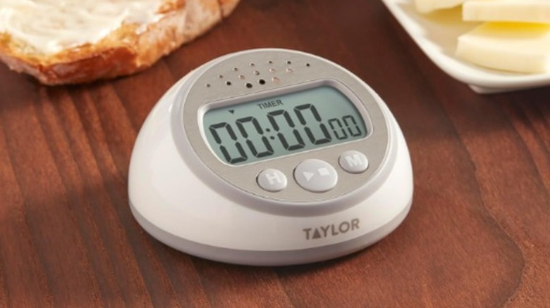 A digital timer placed on a wooden table