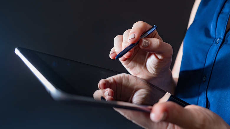 A woman using a tablet and stylus