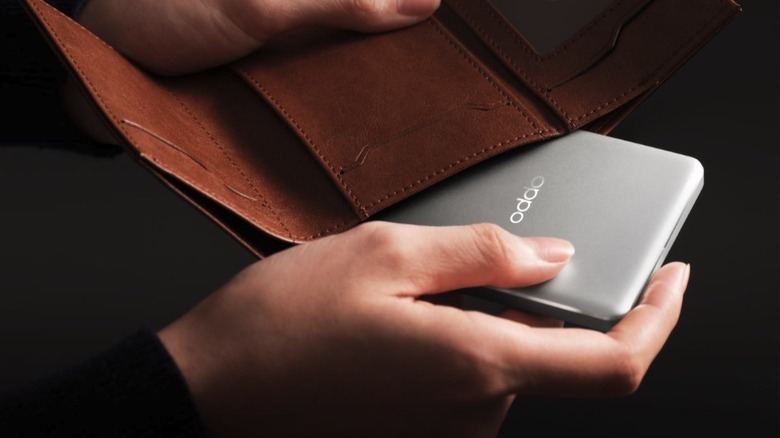 A person fitting the Oppo Magnetic Energy Card Power Bank inside a wallet