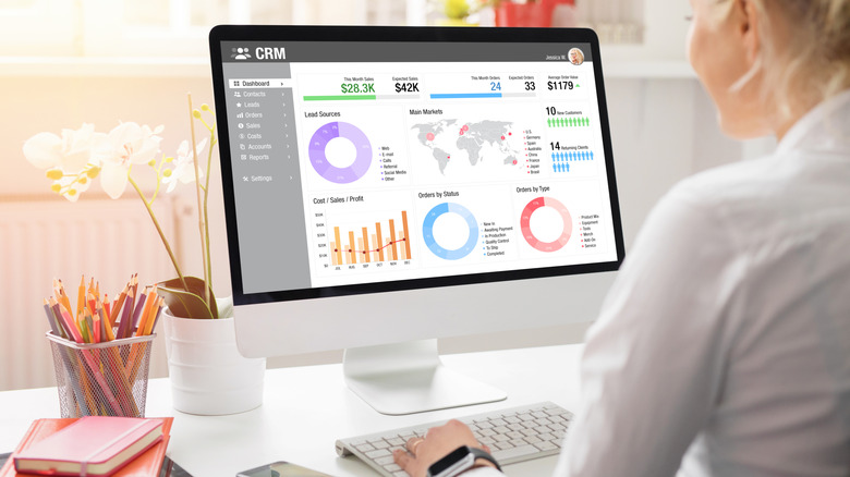 A woman working on Apple desktop computer in an office