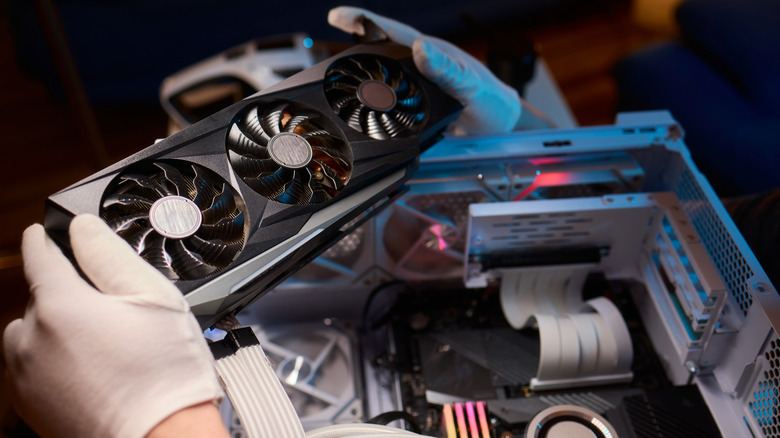 Graphics card held above an open PC case